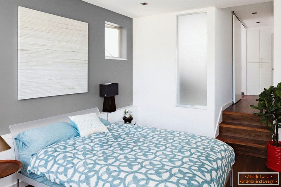 Blaue Bettwäsche und graue Wände im Schlafzimmer