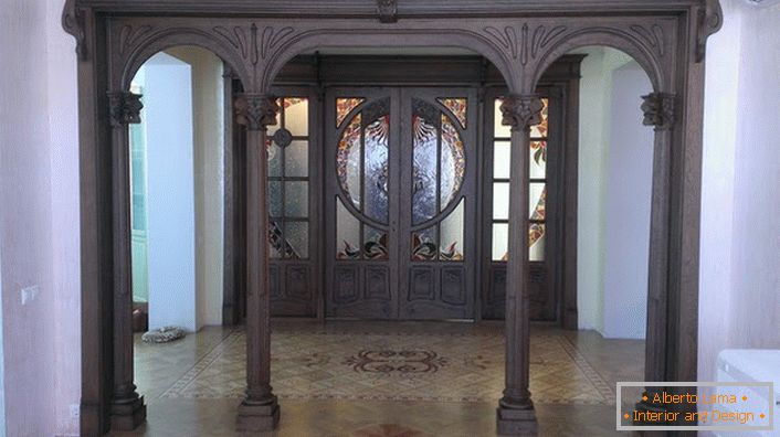 Eingangstüren im Jugendstil sind aus dunklen Hölzern aus teurem Holz gefertigt. Die Halle mit solchen Türen sieht ernst und pompös aus. 