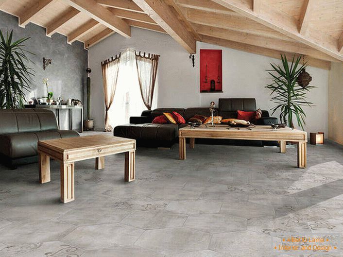 Die Verkleidung von Böden und Wänden imitiert ein raues Finish. Die Holzdecken werden mit Möbeln zu einer gemeinsamen Komposition kombiniert. Eine glückliche Variante des Loft-Stils im Wohnzimmer.