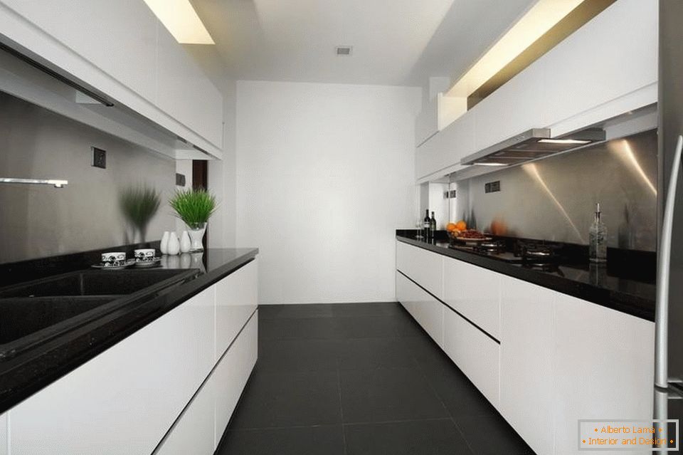Eine schmale und lange weiße Küche mit einem schwarzen Boden